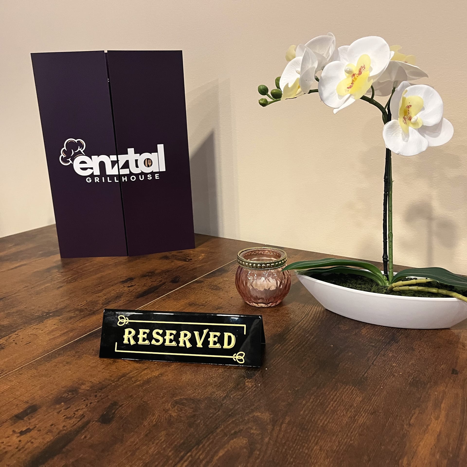 Reservierter Tisch mit Speisekarte und Orchidee